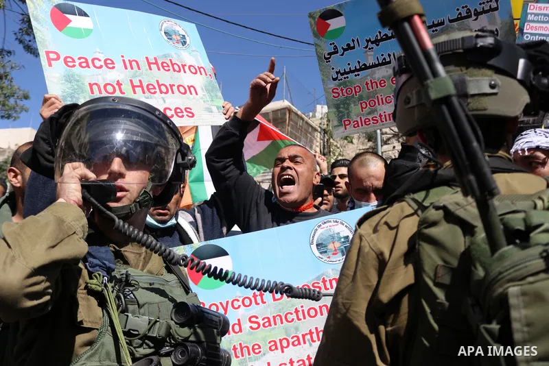 Israeli forces block Palestinian protesters during a demonstration in memory of the 1994 Ibrahimi Mosque massacre, in which a Jewish extremist killed dozens of Palestinian worshippers, in the occupied West Bank city of H...