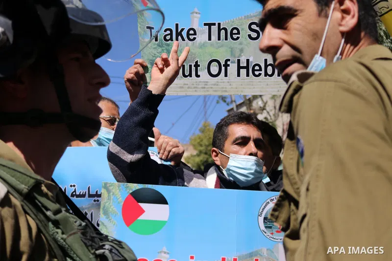 Israeli forces block Palestinian protesters during a demonstration in memory of the 1994 Ibrahimi Mosque massacre, in which a Jewish extremist killed dozens of Palestinian worshippers, in the occupied West Bank city of H...