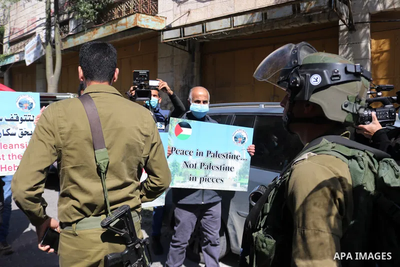 Israeli forces block Palestinian protesters during a demonstration in memory of the 1994 Ibrahimi Mosque massacre, in which a Jewish extremist killed dozens of Palestinian worshippers, in the occupied West Bank city of H...