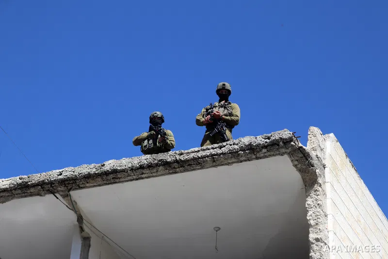 Israeli forces block Palestinian protesters during a demonstration in memory of the 1994 Ibrahimi Mosque massacre, in which a Jewish extremist killed dozens of Palestinian worshippers, in the occupied West Bank city of H...