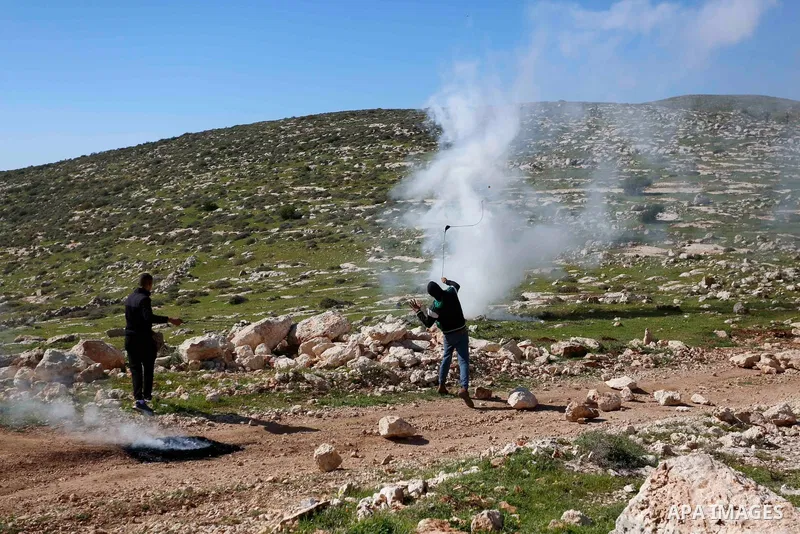 A Palestinian protester returns throwing a tear gas canister at the Israeli forces during a demonstration against the expansion of settlements, in Beit Dajan in the Israeli-occupied West Bank on February 26, 2021. The se...