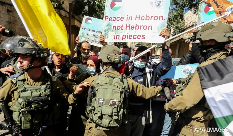 Israeli forces block Palestinian protesters during a demonstration in memory of the 1994 Ibrahimi Mosque massacre, in which a Jewish extremist killed dozens of Palestinian worshippers, in the occupied West Bank city of H...
