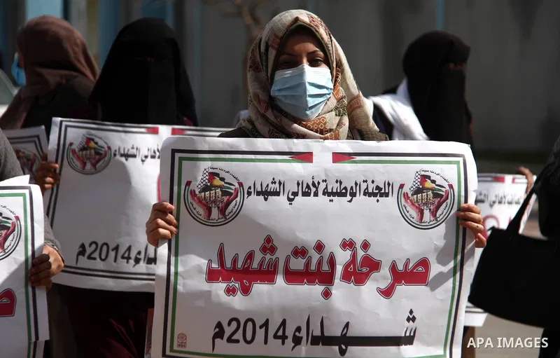 Families of Palestinian martyrs and wounded, take part in a protest against the Palestinian Authority's decision to cut their salaries for seven years, in Gaza city, on February 21, 2021. In January 2019, the PA cut the...