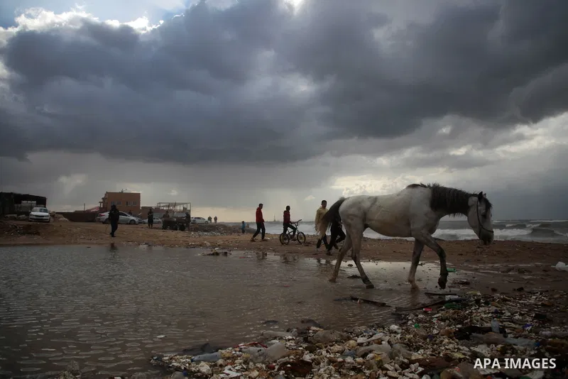 Palestians enjoy during a rainy day, at a beach in Gaza City, on February 18, 2021. The bad weather and snow that hit Palestine yesterday and is expected to continue today caused damage to homes, mainly in the Gaza Strip...