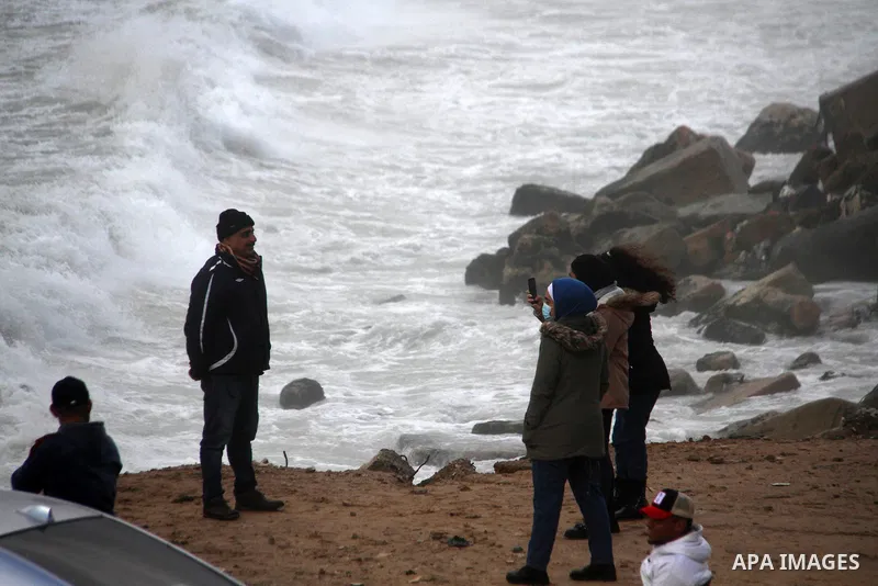 Palestians enjoy during a rainy day, at a beach in Gaza City, on February 18, 2021. The bad weather and snow that hit Palestine yesterday and is expected to continue today caused damage to homes, mainly in the Gaza Strip...
