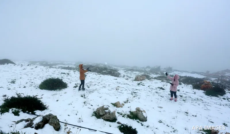Palestinians throw snow balls during a snow storm, in the West Bank city of Nablus on February 18, 2021.The bad weather and snow that hit Palestine yesterday and is expected to continue today caused damage to homes, main...