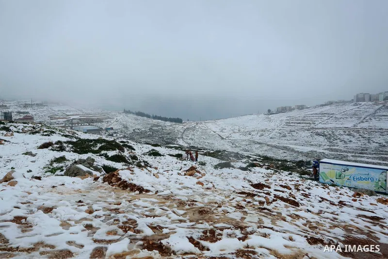 Palestinians enjoy the snow during a snow storm, in the West Bank city of Nablus on February 18, 2021.The bad weather and snow that hit Palestine yesterday and is expected to continue today caused damage to homes, mainly...