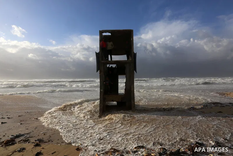 Palestians enjoy during a stormy day, at a beach in Deir El-Balah, in the center of the Gaza Strip, on February 17, 2021. The cloudy, stormy and very cold conditions are expected to continue on Thursday. Scattered torren...