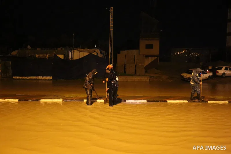 Palestinians work on a flooded street following a heavy rain, in Dair Al Balah in the central of Gaza Strip, on February 17, 2021. The cloudy, stormy and very cold conditions are expected to continue on Thursday. Scatter...