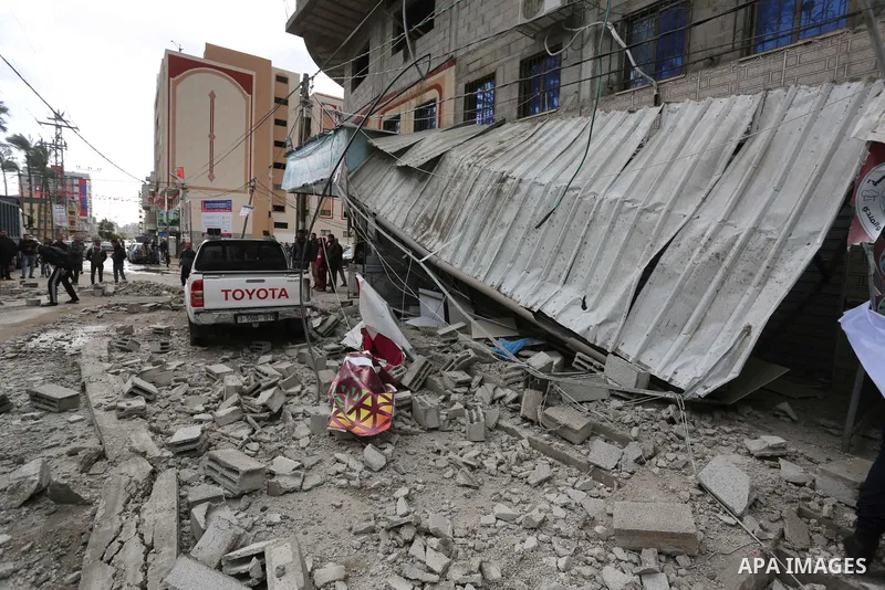 Palestinian Members of the Civil Defense inspect the damage of a wall destroyed by storms, in the Deir al-Balah in the central of Gaza Strip, on February 17, 2021. The cloudy, stormy and very cold conditions are expected...