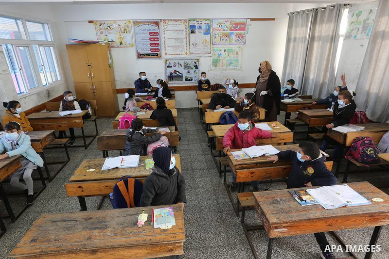 Palestinian students wearing protective face masks, as schools gradually reopen amid the coronavirus disease (COVID-19) outbreak, at their school run by the United Nations Relief and Works Agency (UNRWA) in Deir al-Balah...