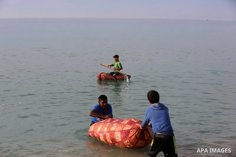 A Palestinian child rides a handmade boat in Mediterranean Sea, amid the outbreak of the coronavirus disease (COVID-19), in Deir Al-Balah in the center of the Gaza Strip on February 8, 2021. In 2018 and early 2019, the P...