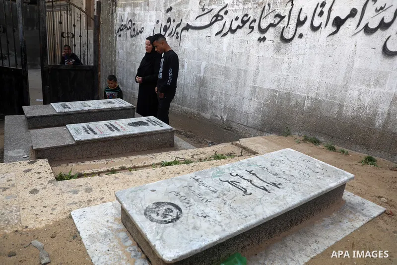 The mother and brother of Mohammad, one of the four children from the extended Bakr family who were killed during the 2014 Israeli-Palestinian conflict, visit the victim's grave in al-Shati refugee camp in Gaza City on F...