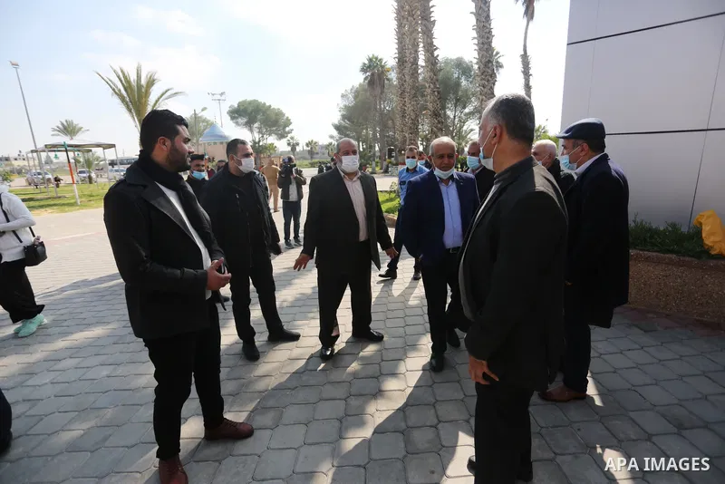 Members of the Palestinian factions are wait to cross into Egypt through the Rafah border crossing, in Rafah in the southern of Gaza Strip, on February 7, 2021. On Sunday, delegations belonging to different Palestinian f...