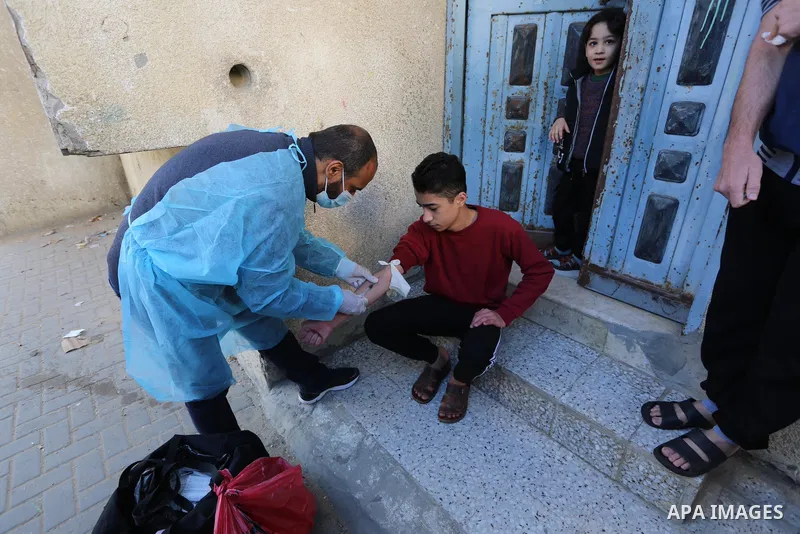 A Palestinian medical worker wearing protective gear, takes a random blood sample, in Deir al-Balah, central of Gaza Strip, on January 30, 2021. Safety and infection control teams at the Ministry of Health in the Gaza St...