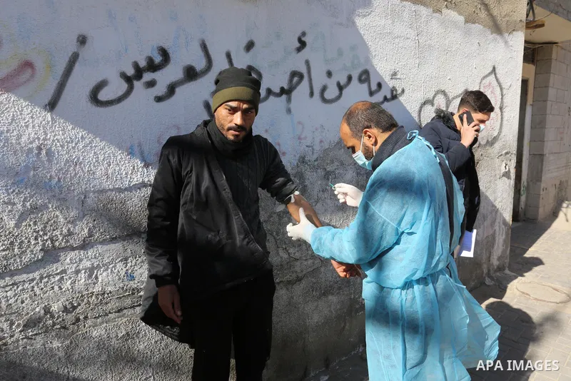 A Palestinian medical worker wearing protective gear, takes a random blood sample, in Deir al-Balah, central of Gaza Strip, on January 30, 2021. Safety and infection control teams at the Ministry of Health in the Gaza St...