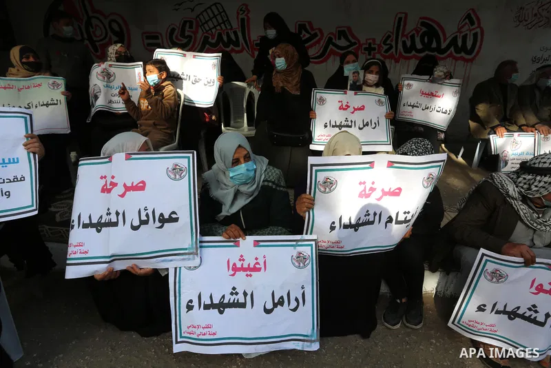 Palestinian families of martyrs and woundeds wearing protective face masks, as they take part in a protest to demand their rights and salaries, in Gaza city, on January 26, 2021. Elections would pose a major risk for Abb...