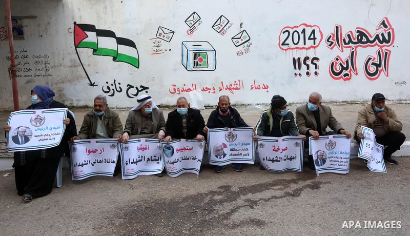Palestinian families of martyrs and woundeds wearing protective face masks, as they take part in a protest to demand their rights and salaries, in Gaza city, on January 26, 2021. Elections would pose a major risk for Abb...