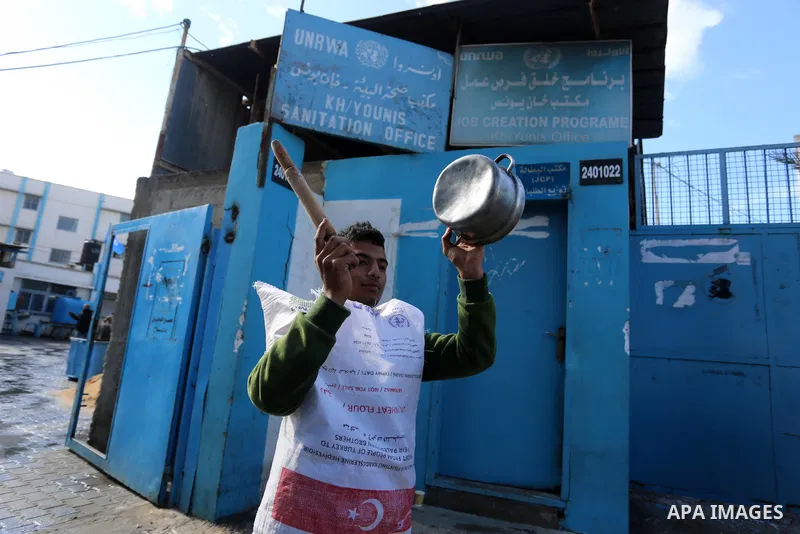 Palestinian children hold banners take part in a protest against the reduction of the food basket provided by the United Nations Relief and Works Agency for Palestine Refugees (UNRWA), in Khan Yunis in the southern Gaza...