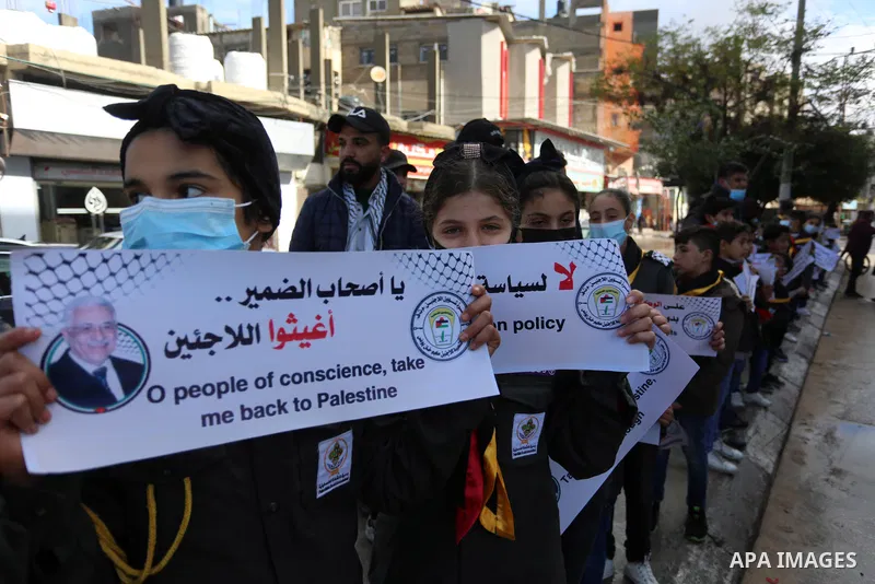 Palestinian children hold banners take part in a protest against the reduction of the food basket provided by the United Nations Relief and Works Agency for Palestine Refugees (UNRWA), in Khan Yunis in the southern Gaza...