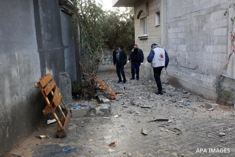 Palestinian men inspect a damaged house near the border fence with Israel, in Maghazi refugee camp in the central Gaza Strip, on January 20, 2021. Israeli tank fire struck a number of sites in the Gaza Strip, including a...