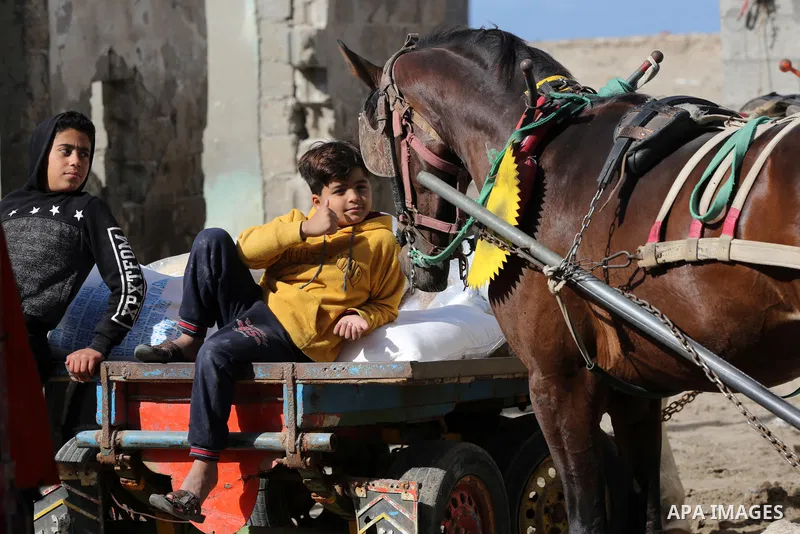 Palestinians wait to receive food supplies at an aid distribution center, amid the outbreak of the coronavirus disease (COVID-19), in al-Shati refugee camp, west Gaza city on January 14, 2021. Palestinian refugees in the...