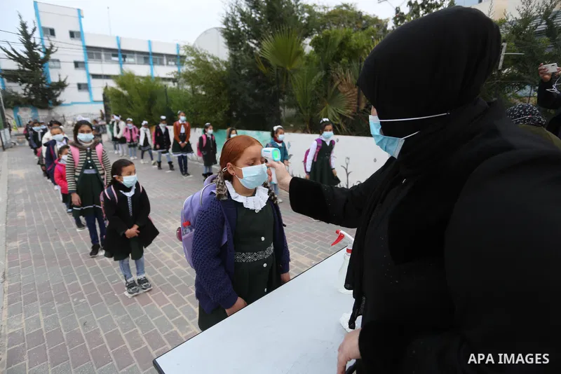 Palestinian students wear protective face masks, as schools gradually reopen amid the coronavirus disease (COVID-19) outbreak, at their school in Khan Younis in the southern of Gaza strip, on January 13, 2021. In a writt...
