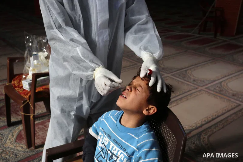 A Palestinian medical worker wearing protective gear, takes a random swab sample for COVID-19 testing inside a mosque, in Deir al-Balah, central of Gaza Strip, on January 11, 2021. The Palestinian Authority (PA) has said...
