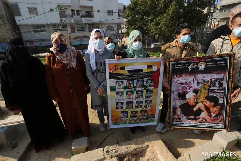 Palestinians carry banners with pictures of Palestinian martyrs, on the anniversary of the Palestinian martyr's day, at a cemetery in Nuseirat camp in the middle of the Gaza Strip, on January 7, 2020. In January 1965, Ah...