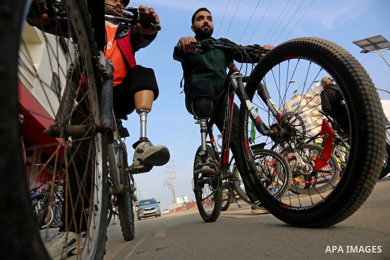 Palestinian amputees take part in Bicycle race during an event in Deir Al-Balah in the center of the Gaza Strip, on January 6, 2021. Sweeping Israeli restrictions on the movement of people and goods, at times exacerbated...
