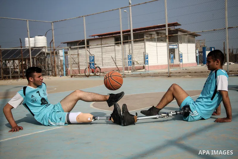 The two Disabled Palestinian players who lost their feet, Ahmed Abu Daqin, 17, and Muhammad Aliwa, 18, play basketball in a playground on the beach, in Gaza City on January 6, 2020. According to official statistics from...