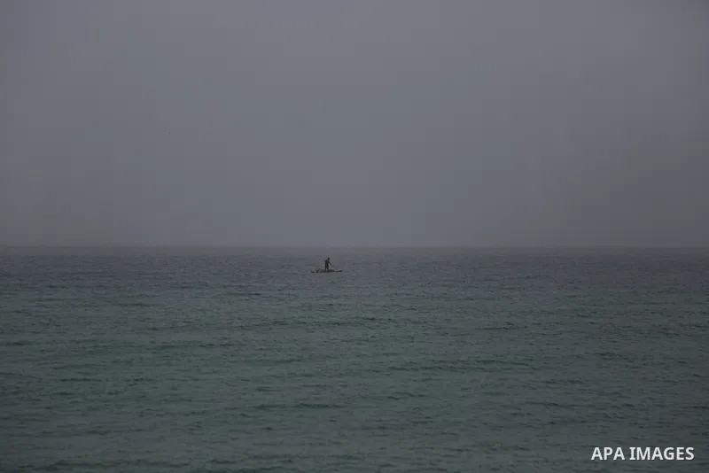 Palestinian fishermen work on their fishing boats during a heavy fog, in Gaza city, on January 5, 2021. Photo by Mahmoud Alhende