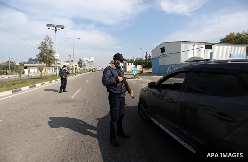 Palestinian policemen, wear face masks, stand guard during a complete closure amid the spread of the Coronavirus COVID-19, in the central of Gaza Strip, on January 2, 2021, in the fourth week after the Ministry of Interi...