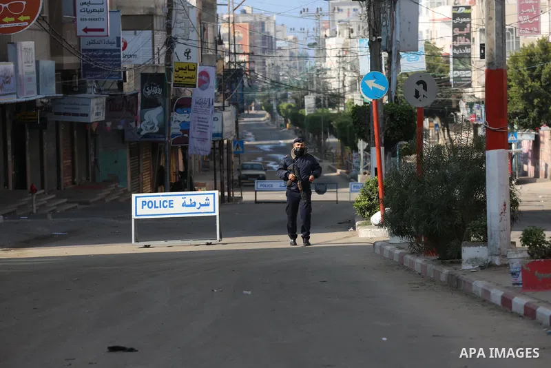 Palestinian policemen wear face masks, guard a barrier blocking a road during a complete closure amid the spread of the Coronavirus COVID-19, in Deir Al-Balah in the center of the Gaza Strip, on January 1, 2021, in the f...