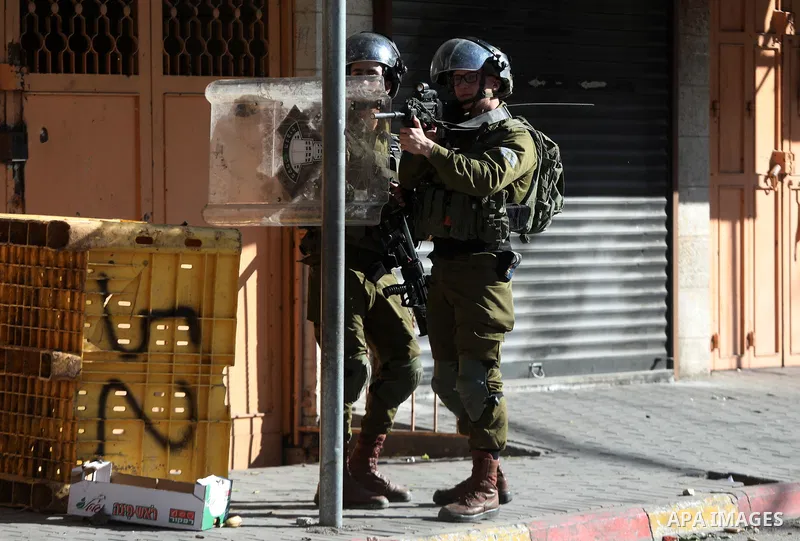 Palestinian protesters clash with Israeli troops in the West Bank city of Hebron on January 7, 2022. Photo by Mamoun Wazwaz
