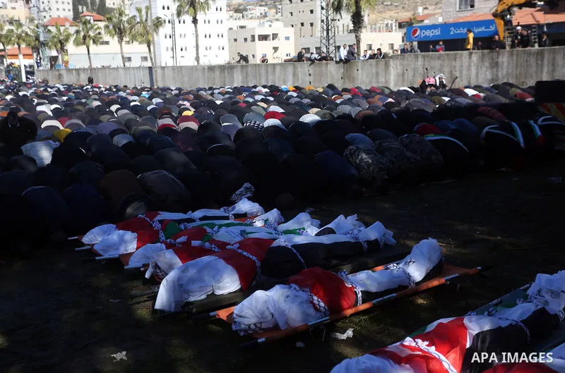 Palestinians attend the funeral of 8 workers who died a day earlier in a traffic accident while working in the Jordan Valley, on January 7, 2022, in the village of Aqraba, east of the West Bank city of Nablus. The worker...