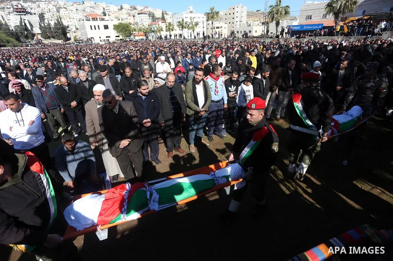 Palestinians attend the funeral of 8 workers who died a day earlier in a traffic accident while working in the Jordan Valley, on January 7, 2022, in the village of Aqraba, east of the West Bank city of Nablus. The worker...
