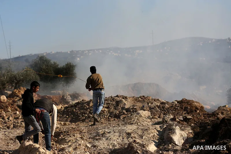 Palestinian protesters clash with Israeli security forces following a demonstration against settlements in the village of Beita in the West Bank, on January 7, 2022. Photo by Wajed Nobani