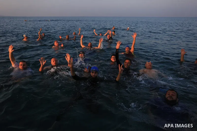 Elderly Palestinians swim in the Mediterranean sea during the winter, in Beit Lahia in the northern Gaza Strip, on January 8, 2022. Swimming lovers swim early in the morning during winter in the Mediterranean sea. The be...