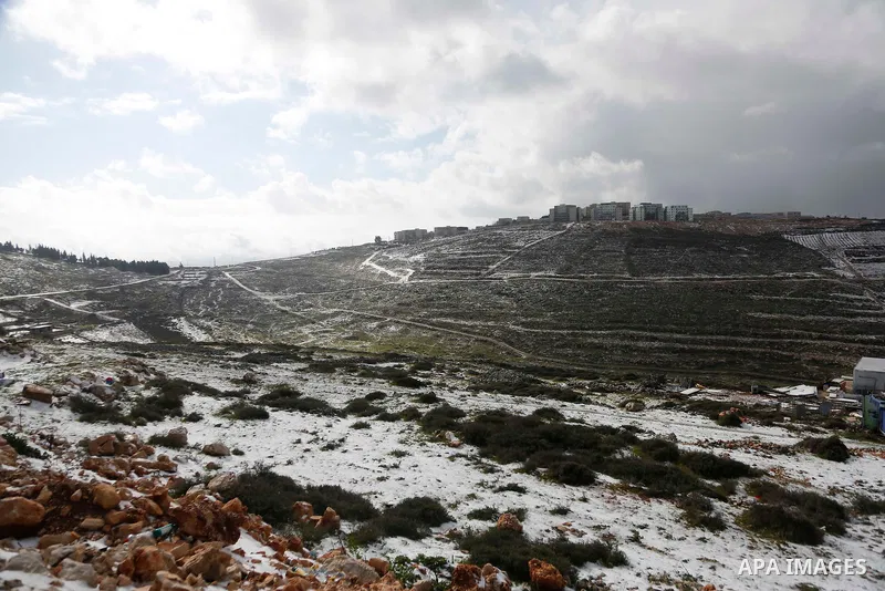 Palestinians play with snow during a snowstorm on top of Mount Gerizim, near the West Bank city of Nablus January 27, 2022. The low pressure is set to continue to affect the region today, paving the way to cloudy, stormy...
