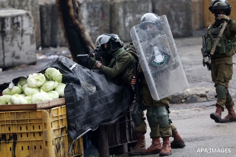 Israeli security forces take position during clashes with Palestinian protesters against settlements in the West Bank city of Hebron on January 28, 2022. Photo by Mamoun Wazwaz