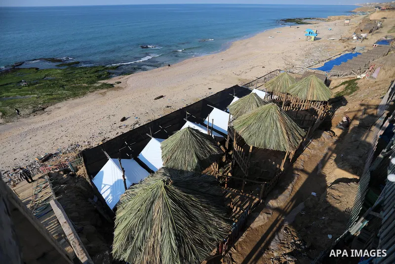 Palestinian workers do expansion works at a cafe built in the Malaysian way in the form of hanging huts at the beach of Deir al-Balah's sea on January 30, 2022. Photo by Ashraf Amra