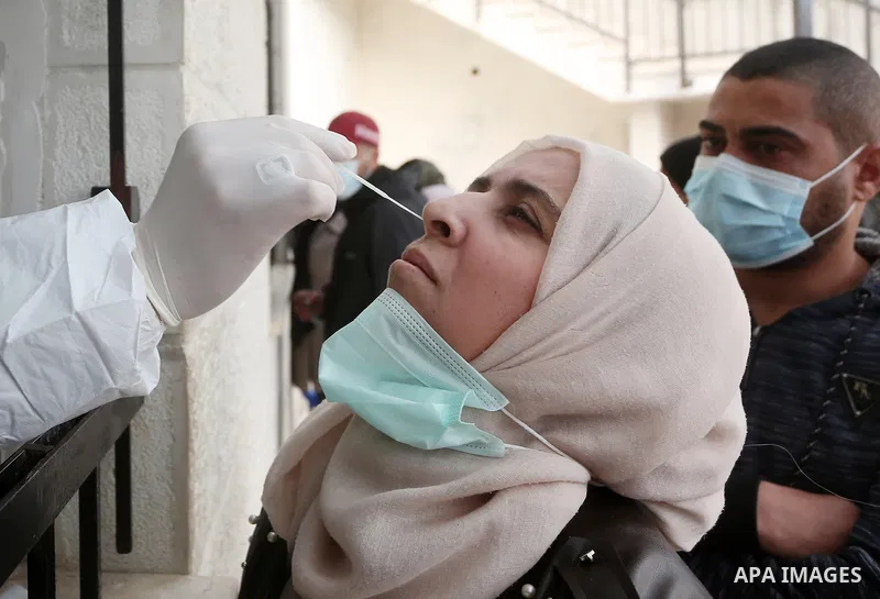 A medic from the Palestinian Health Ministry takes swab samples from people to test for the coronavirus, in the West Bank city of Nablus on January 31, 2022. Daily Covid-19 cases in Palestine continued to rise and reache...