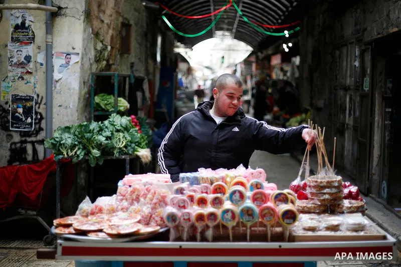 Palestinians shop at a market in the Old city of the West Bank city of Nablus on January 31, 2022. Photo by Shadi Jarar'ah