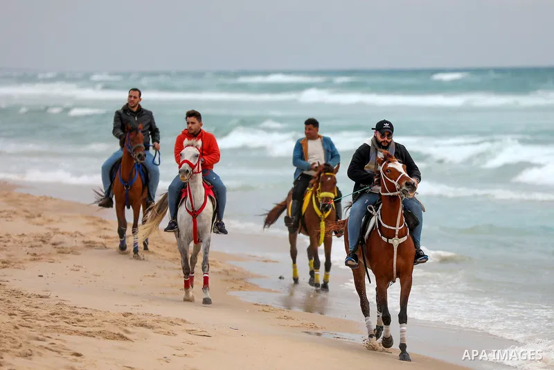 Palestinians enjoy on the beach of Gaza city on January 31, 2022. The beach is one of the few open public spaces in this densely populated city. Now a ceaseless conflict that seems to impinge on nearly every aspect of li...