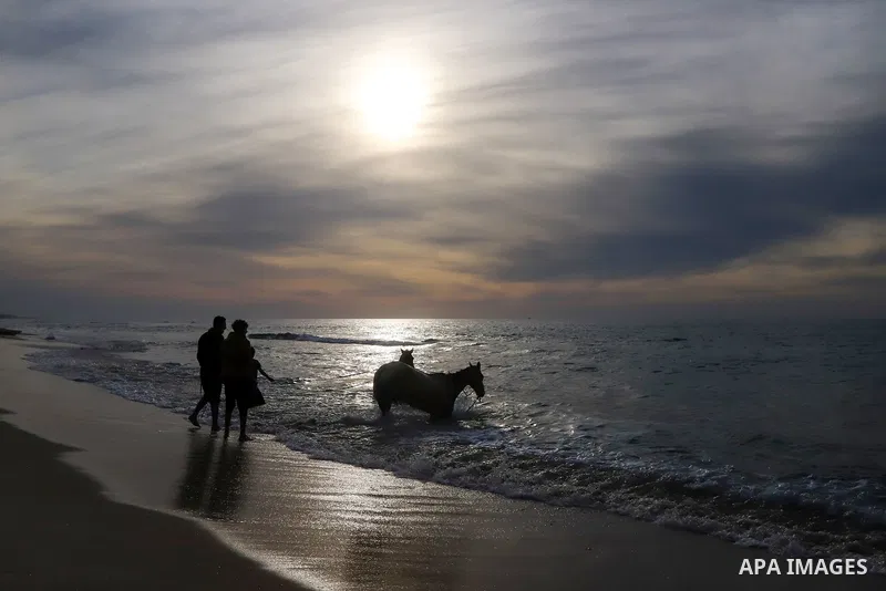 Palestinians enjoy on the beach of Gaza city during sunset on Feb. 02, 2022. The beach is one of the few open public spaces in this densely populated city. Now a ceaseless conflict that seems to impinge on nearly every a...