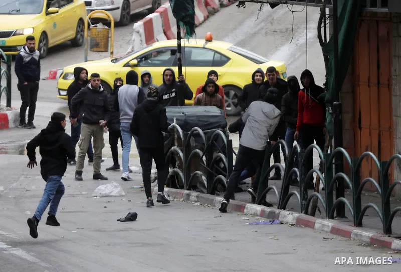 Palestinian protesters hurl stones towards Israeli security forces during clashes against settlements in the West Bank city of Hebron on Feb. 4, 2022. Photo by Mamoun Wazwaz