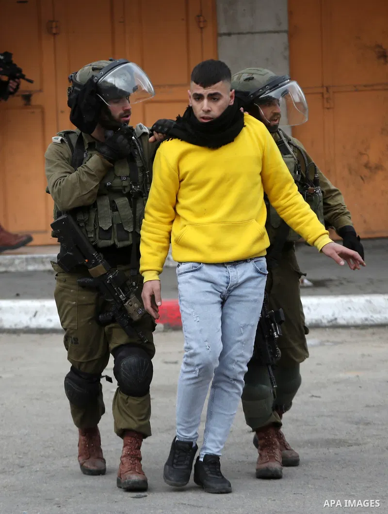 Israeli security forces detain a Palestinian youth during clashes against settlements in the West Bank city of Hebron on Feb. 4, 2022. Photo by Mamoun Wazwaz