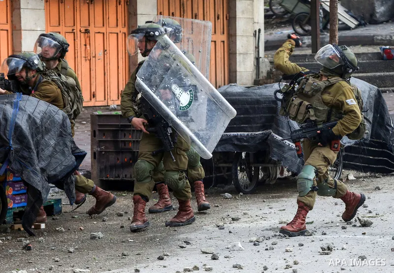 Israeli troops take position during clashes with Palestinian protesters against the killing of three Palestinians this week by Israeli forces, in the West Bank city of Hebron on Feb. 11, 2022. Photo by Mamoun Wazwaz