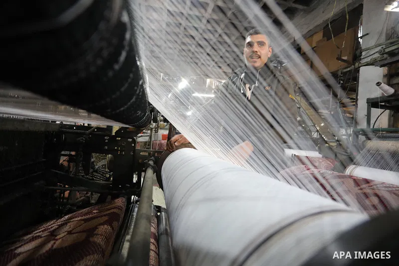 Palestinian workers work in a mat factory in Jabalia, in the northern Gaza Strip on February 13, 2022. A mat is a hard rug that generally is placed on a floor or other flat surface, mats may cover entire rooms, or be use...